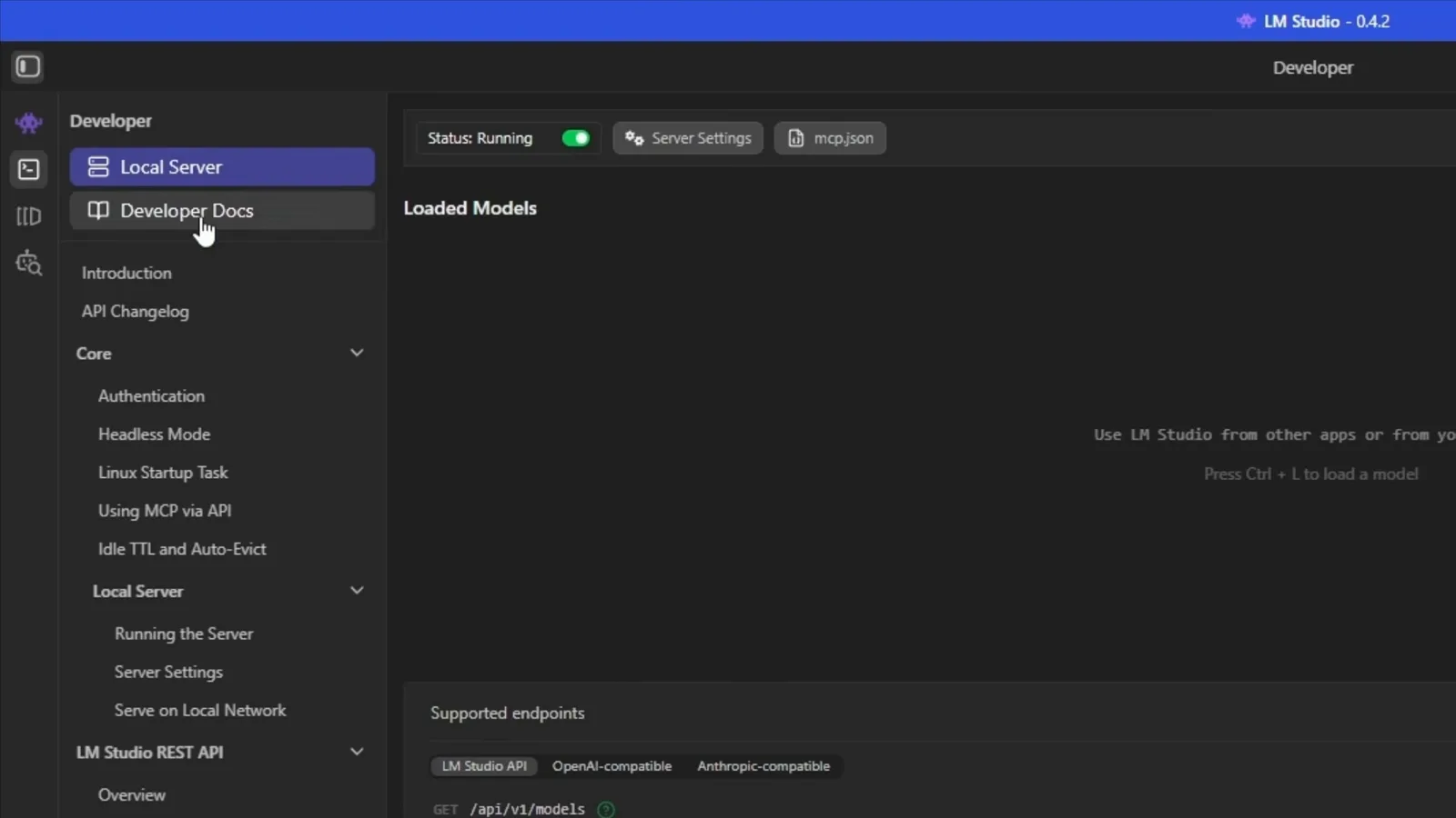 LM Studio 0.4.2 Developer tab Local Server page with the Status Running toggle switched on above an empty Loaded Models panel and the OpenAI-compatible supported endpoints